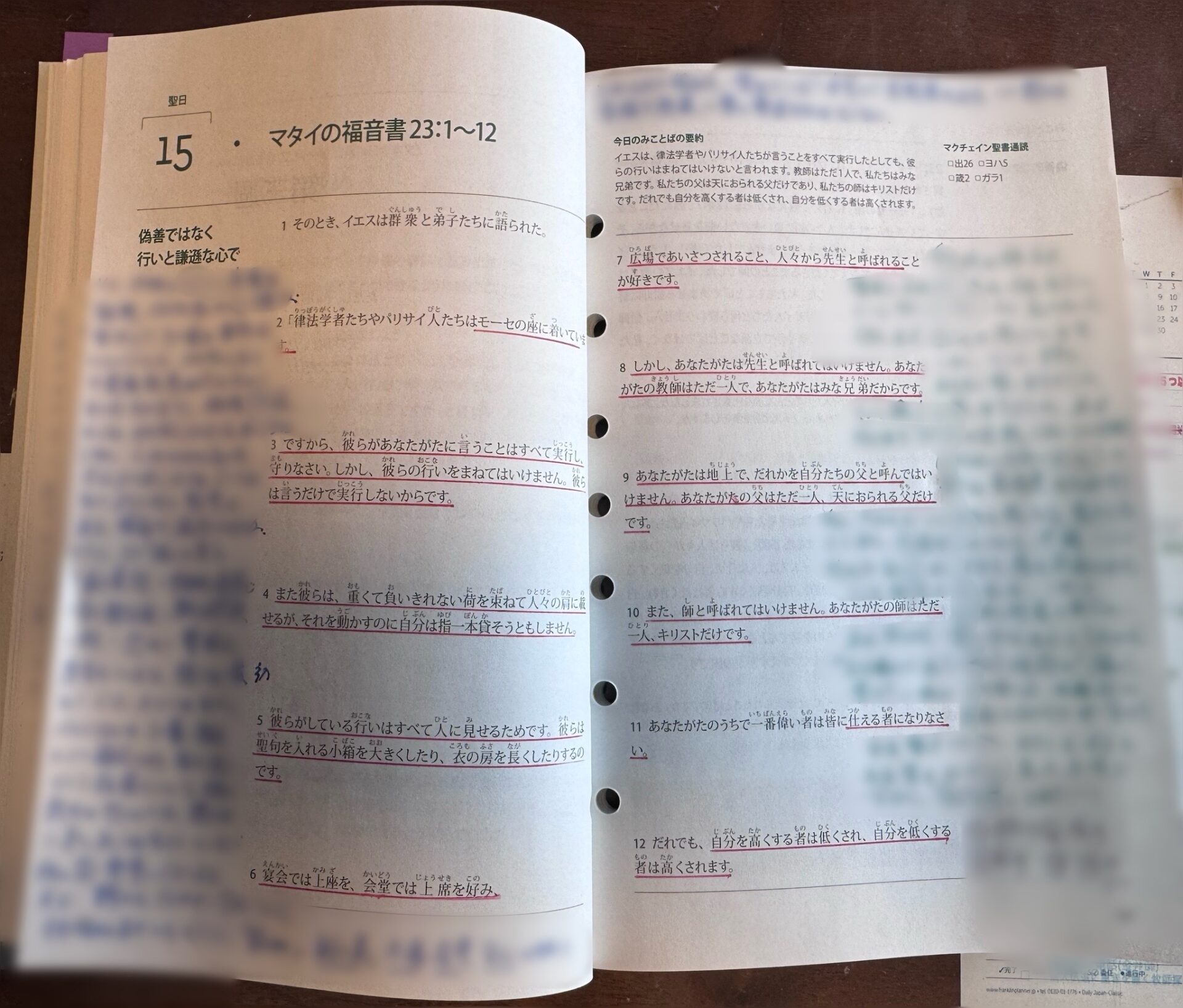 マタイの福音書23章1〜12節が開かれた聖書テキストの見開きページ。本文の複数箇所に赤い下線が引かれている。